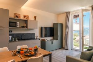 a living room with a table and a kitchen at Cà di Cambret with lake View in Stresa
