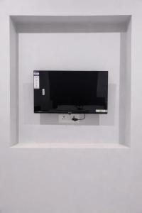 a flat screen tv hanging on a white wall at Chouhan Resort in Katihār