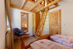 a bedroom with a ladder and a bed and a chair at Müllerleile Hof in Haslach im Kinzigtal