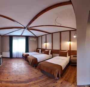 a row of beds in a room with wooden floors at Diamond Koru Hotel in Amasra