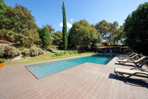 a swimming pool with lounge chairs on a wooden deck at Casa de Andrães Camélias in Marco de Canaveses