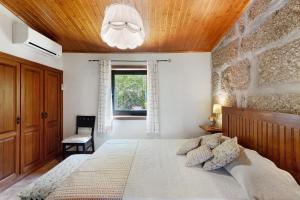 a bedroom with a large bed with a wooden ceiling at Casa de Andrães Camélias in Marco de Canaveses +23 photos