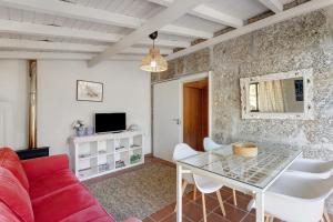 a living room with a red couch and a glass table at Casa de Andrães Camélias in Marco de Canaveses
