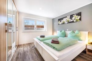 a bedroom with a large white bed with green pillows at Ferienwohnung Leuchtturm in Osterbruch
