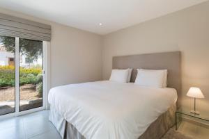 a bedroom with a large bed and a window at Villa Leeroy in Almancil