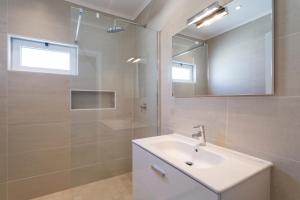 a white bathroom with a sink and a mirror at Villa Leeroy in Almancil +6 photos