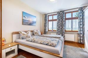 a bedroom with a bed and two windows at Ferienhaus Himmelreich in Barlt