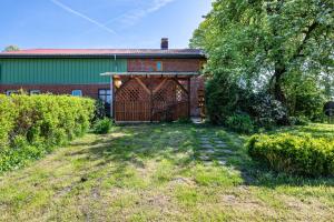 a barn with a large wooden gate in a yard at Ferienhaus Himmelreich in Barlt