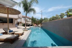 a swimming pool with two lounge chairs and an umbrella at Villa Dionysia Studio S3 in Alikanas