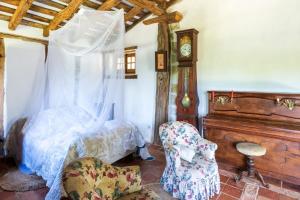 a bedroom with a bed and a chair and a clock at Dependance avec Jacuzzi in Arcangues