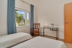 a bedroom with two beds and a chair and a window at Casa Palmeras in Almuñécar +37 photos