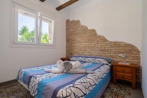 a bedroom with a bed and a brick wall at Casa rural Mestre in Deltebre +22 photos