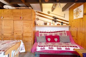 a bedroom with a bed with red pillows on it at Petit chalet mitoyen Pyrénées 2000 in Bolquere Pyrenees 2000