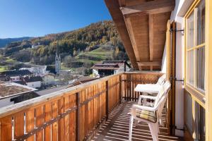 a balcony with two chairs and a view at Haus Peer Burgeis in Malles Venosta