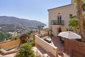 a balcony of a house with an umbrella at Casa Palmeras in Almuñécar