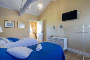 a bedroom with two beds and a television on the wall at Apartamento La Calleja in Arzúa