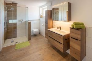 a bathroom with a sink and a shower and a toilet at Ferienwohnung Egg-Hof in Bad Grönenbach +19 photos