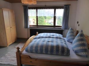 a bedroom with a bed with blue pillows and a window at Ferienhaus am Bach in Wieden