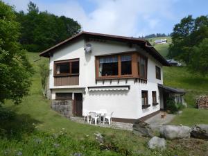 a white house with a table and chairs at Ferienhaus am Bach in Wieden