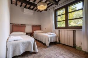 a room with two beds and a window at Podere San Biagio in Capalbio