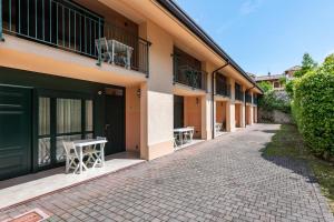 a row of buildings with tables and chairs on a street at Nice apartment Le Vele Garda Lake in Toscolano Maderno
