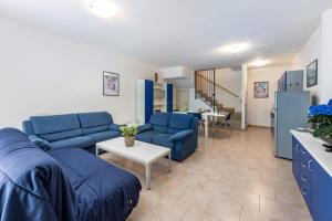 a living room with a blue couch and a table at Nice apartment Le Vele Garda Lake in Toscolano Maderno