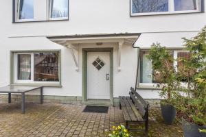 a white house with a bench and a door at Ferienwohnung Greitemann in Eslohe