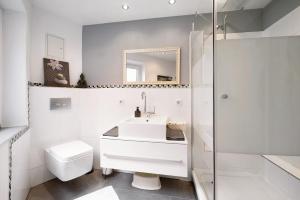 a white bathroom with a sink and a shower at Ferienwohnung My Suite Home in Illingen +15 photos