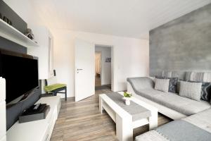 a living room with a couch and a tv at Ferienwohnung My Suite Home in Illingen