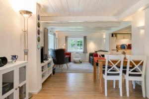 a dining room and living room with a table and chairs at Ferienhaus Reetkate Breklum in Breklum