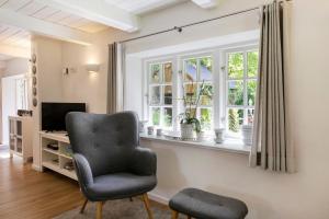 a living room with a chair and a window at Ferienhaus Reetkate Breklum in Breklum