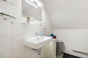 a bathroom with a sink and a mirror at Ferienhaus Reetkate Breklum in Breklum +23 photos