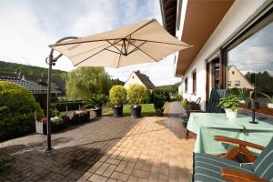 a patio with a table and an umbrella at Ferienwohnung Tibo in Wimbach