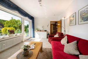 a living room with red furniture and a large window at Ferienwohnung Tibo in Wimbach