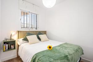 a bedroom with a bed with a sunflower on it at Limón Lunero in Málaga +17 photos