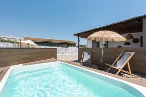 a pool with two chairs and an umbrella on a house at Limón Lunero in Málaga