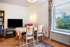 a dining room with a table and chairs and a television at Haus Sonnenschein in Pahlen