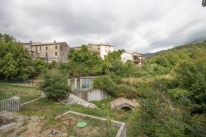a group of buildings on a hill with trees at A Casa D'amore in Bastelica