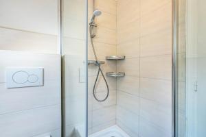 a bathroom with a shower with a glass door at Haus Sonnenschein in Pahlen +18 photos