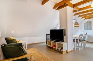 a living room with a couch and a tv and a table at Marienstraße, 54m², ruhig gelegen in Herdwangen-Schönach