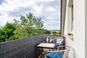 a balcony with two chairs and a table at Marienstraße, 54m², ruhig gelegen in Herdwangen-Schönach