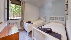 a room with two beds and a table and a window at Costacabana - Villa Paris in Lloret de Mar +15 photos