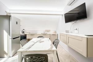 a white kitchen with a table and chairs at Orchidea Celeste Bed and Breakfast in Manfredonia