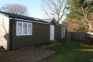 a small house in a yard next to a fence at Golden Cross Holiday Park in Hailsham