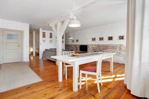 a kitchen and living room with a white table and chairs at Alte Seifensiederei 3 in Stralsund