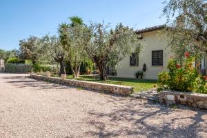 a house with trees and a gravel driveway at Podere San Biagio in Capalbio