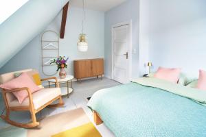 a bedroom with a bed and a chair and a table at Große Atelierwohnung Barrierefrei in Meezen