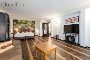 a living room with a bed and a tv at Boutique Suites anno 1789 by Kamelu in Gengenbach +100 photos