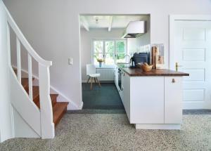 a white kitchen with a counter and a staircase at Große Atelierwohnung Barrierefrei in Meezen +15 photos