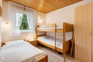 a bedroom with two bunk beds and a window at Ferienhaus Landhaus Loose in Schashagen